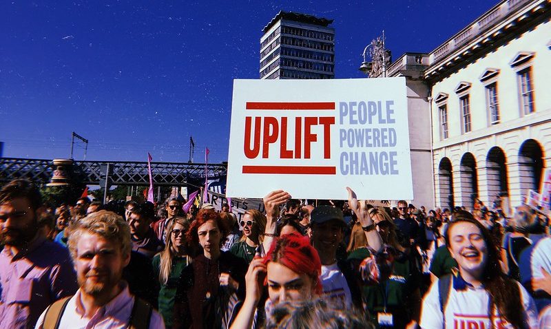 A sign with the Uplift logo among a crowd