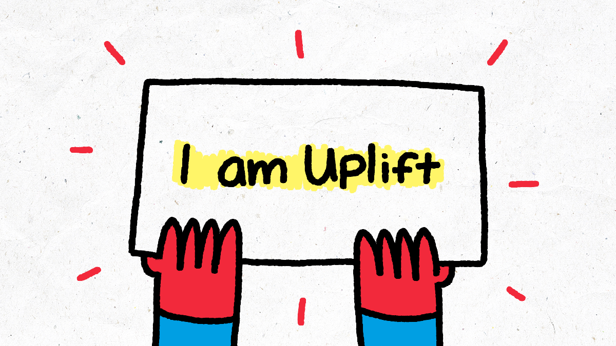 A placard saying 'I am Uplift' being held by two hands